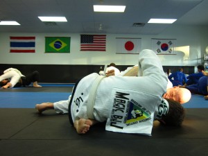 Members of Magic BJJ rolling, one with the logo on the back.